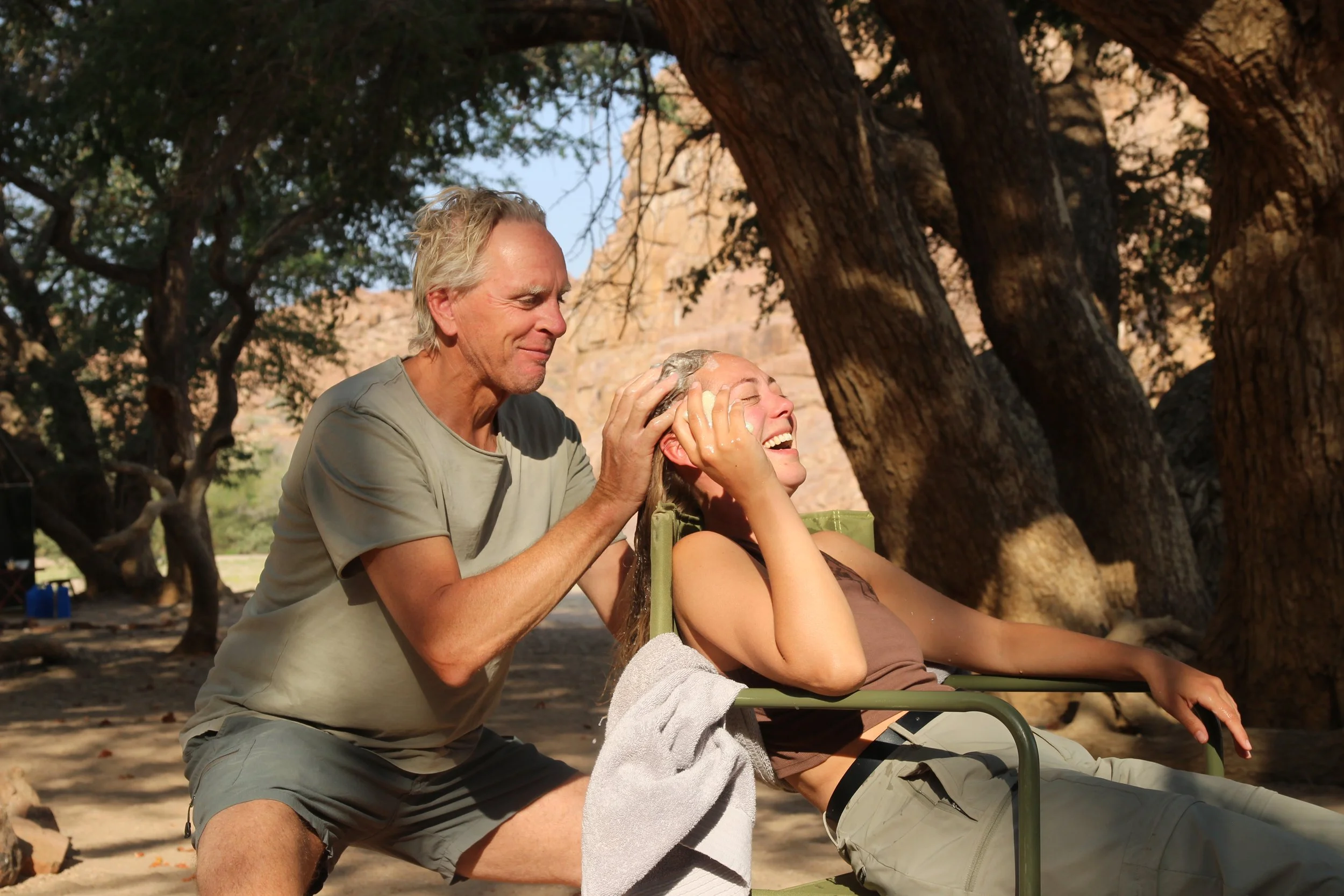 Amber Van Gool en haar papa Joris lachen samen in de natuur in Namibië