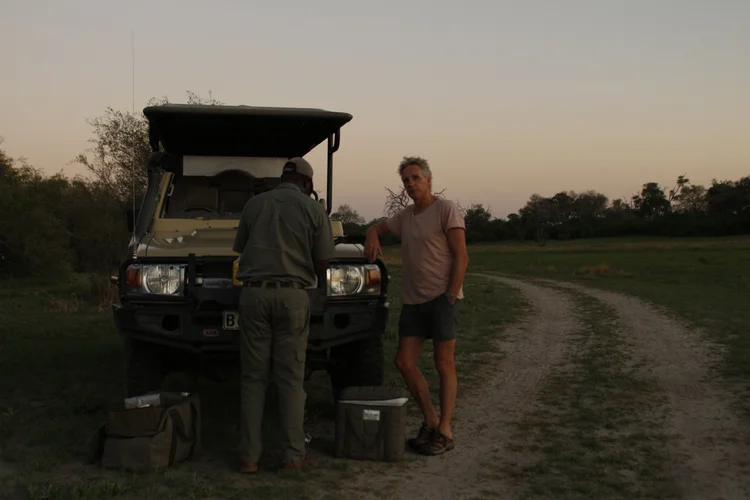 Joris en een lokale gids bij het safarivoertuig in de schemering